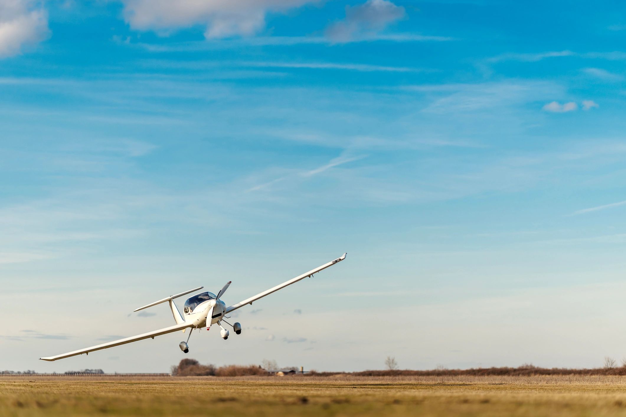 Small airplane taking off from a grass airfield